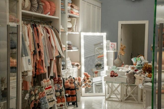 Interior view of a small boutique with clothing, shoes, and home decor