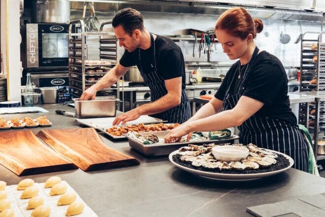 Two caterers preparing appetizers