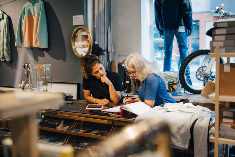 shop owner talking to employee at desk
